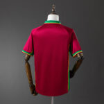 Back view of a maroon sports jersey on a mannequin, with green and yellow trim at the collar and sleeve cuffs.