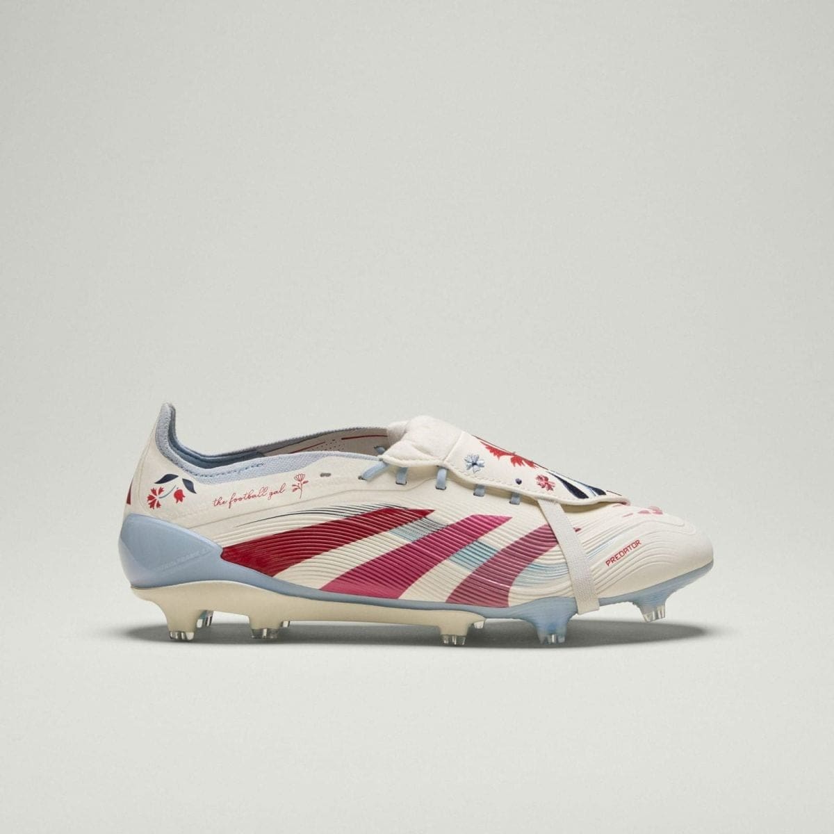 Side view of a white Adidas Predator football boot with pink and blue floral pattern on a light background, product shot.