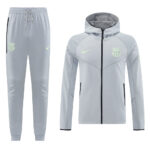 Light gray FC Barcelona training tracksuit: zip-up hoodie with neon logo and crest, and matching jogger pants with drawstring waist and side pockets.