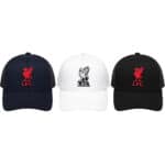 Three Liverpool FC baseball caps in navy, white, and black with embroidered L.F.C. crest (red on navy and black, black on white).