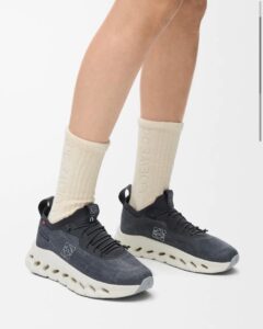 Lower legs wearing dark gray knit sneakers with a chunky white sole and cream crew socks.
