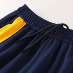 Close-up of navy fabric with a yellow interior lining and an elastic waistband.