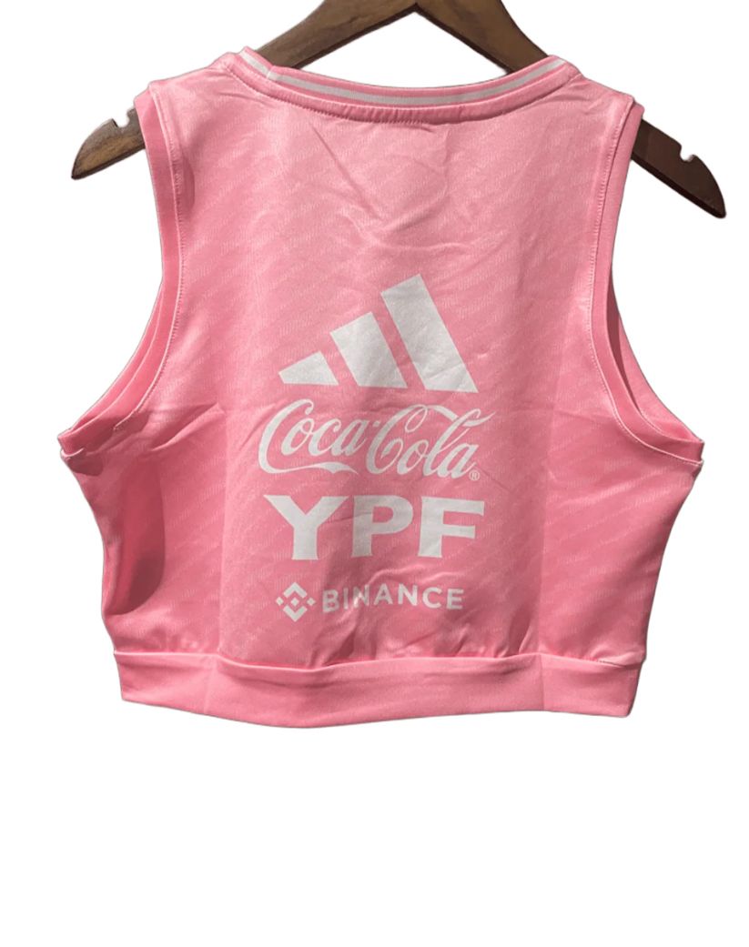 07537077-c085-4f57-8bec-486ba59c1bb4 | UAE SPORT STORE Back view of a pink sleeveless cropped athletic top with white Coca-Cola, YPF, and Binance logos on the back, hanging on a wooden hanger.
