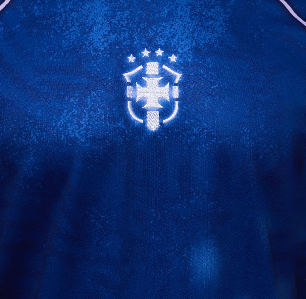 07afd66f-4598-4a16-a52a-aba5ffbb2c64 | UAE SPORT STORE Blue athletic jersey fabric with a white embroidered crest: a shield and cross motif with five stars above.