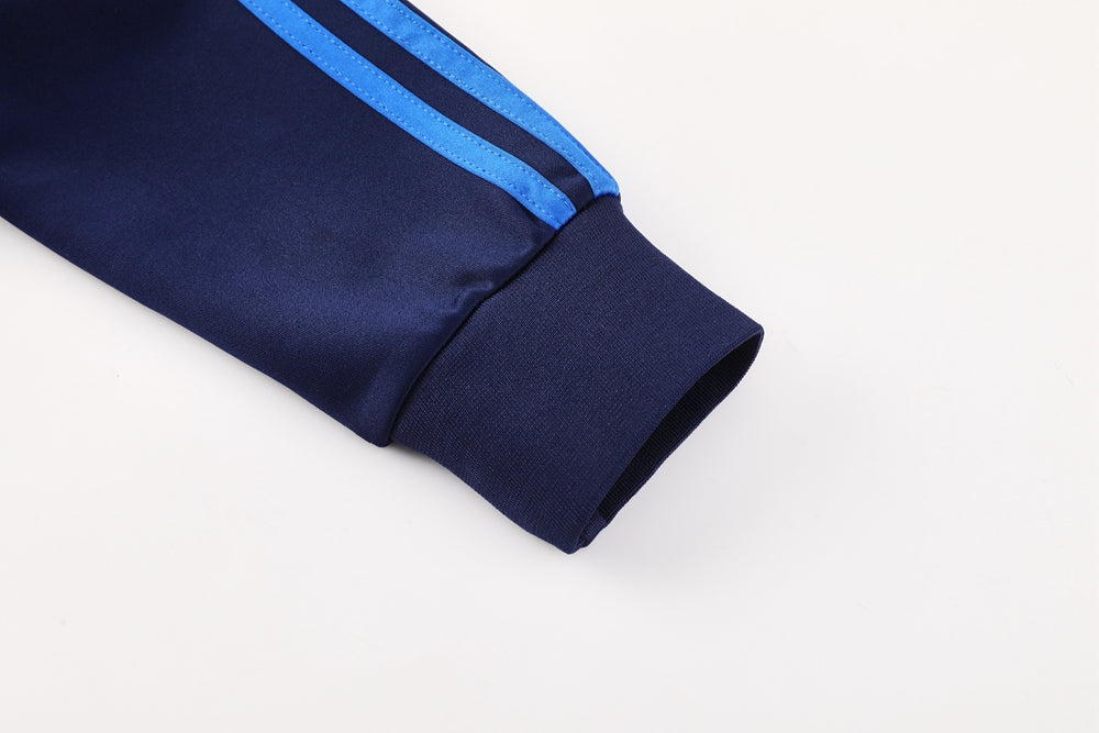 0807b33e | UAE SPORT STORE Navy blue track jacket sleeve with light blue side stripes and a ribbed cuff fold showing inner fabric
