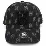 Black baseball cap with an all-over gray AMIRI monogram pattern and a large black embroidered logo on the front; curved brim and side strap detail with AMIRI badge on the brim