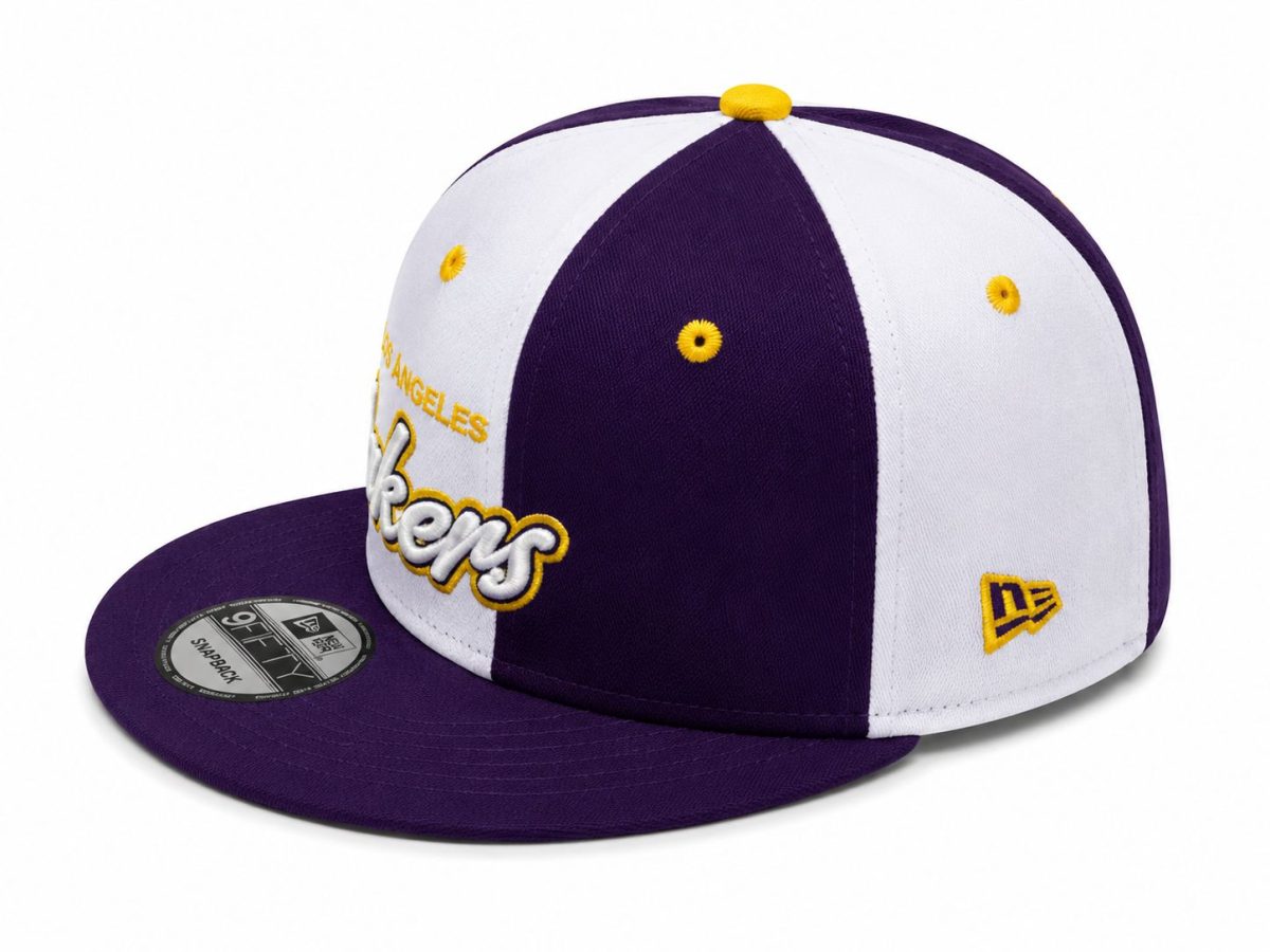 Purple and white Los Angeles Lakers snapback cap with yellow embroidery and New Era logo on the side, shown from a low angle.