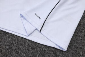 Close-up of a light lavender shirt sleeve laid on a gray carpet, showing the 'NEVER READY' branding near the cuff.