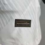 Close-up of white textured fabric with a black patch label reading 'ENGINEERED' and a small yellow Nike swoosh nearby.