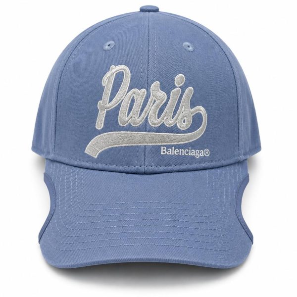 Blue baseball cap with white embroidered 'Paris' script and 'Balenciaga' logo on the front panel; curved brim and structured crown.