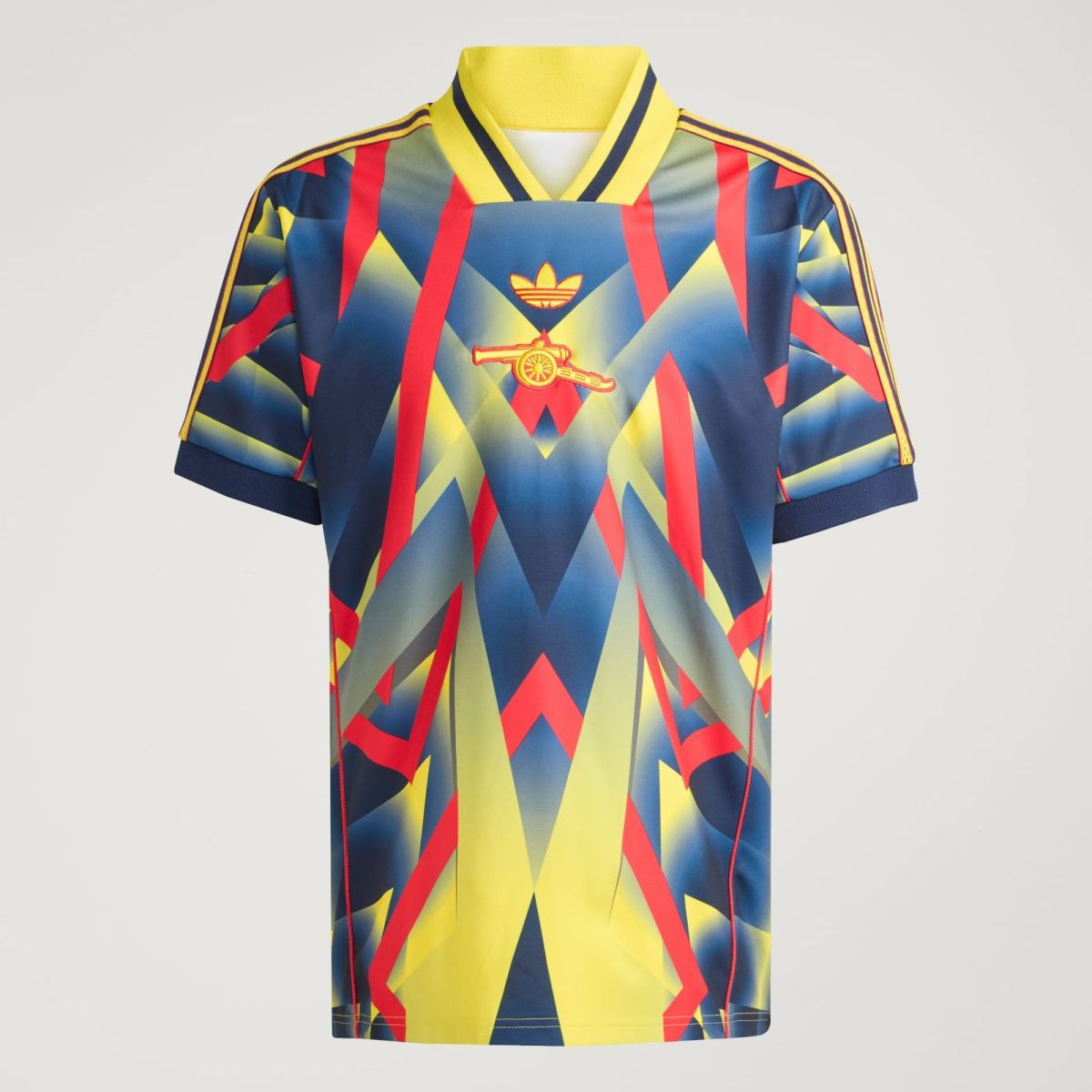 Colorful geometric-pattern jersey with yellow collar and Adidas logo on chest, featuring a small cannon emblem at center.
