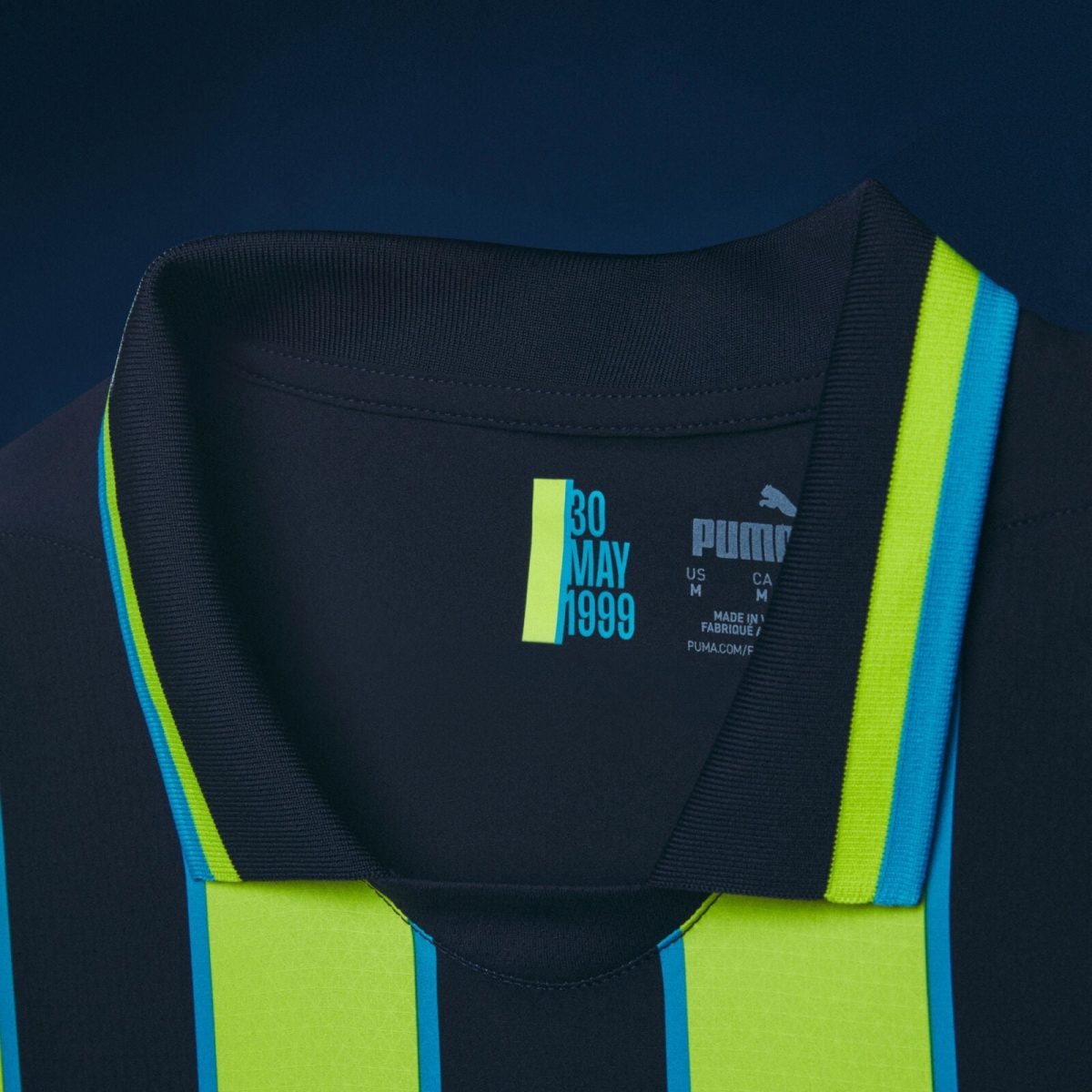 Close-up of a dark jacket with neon yellow and blue reflective stripes and a label reading 30 MAY 1999.
