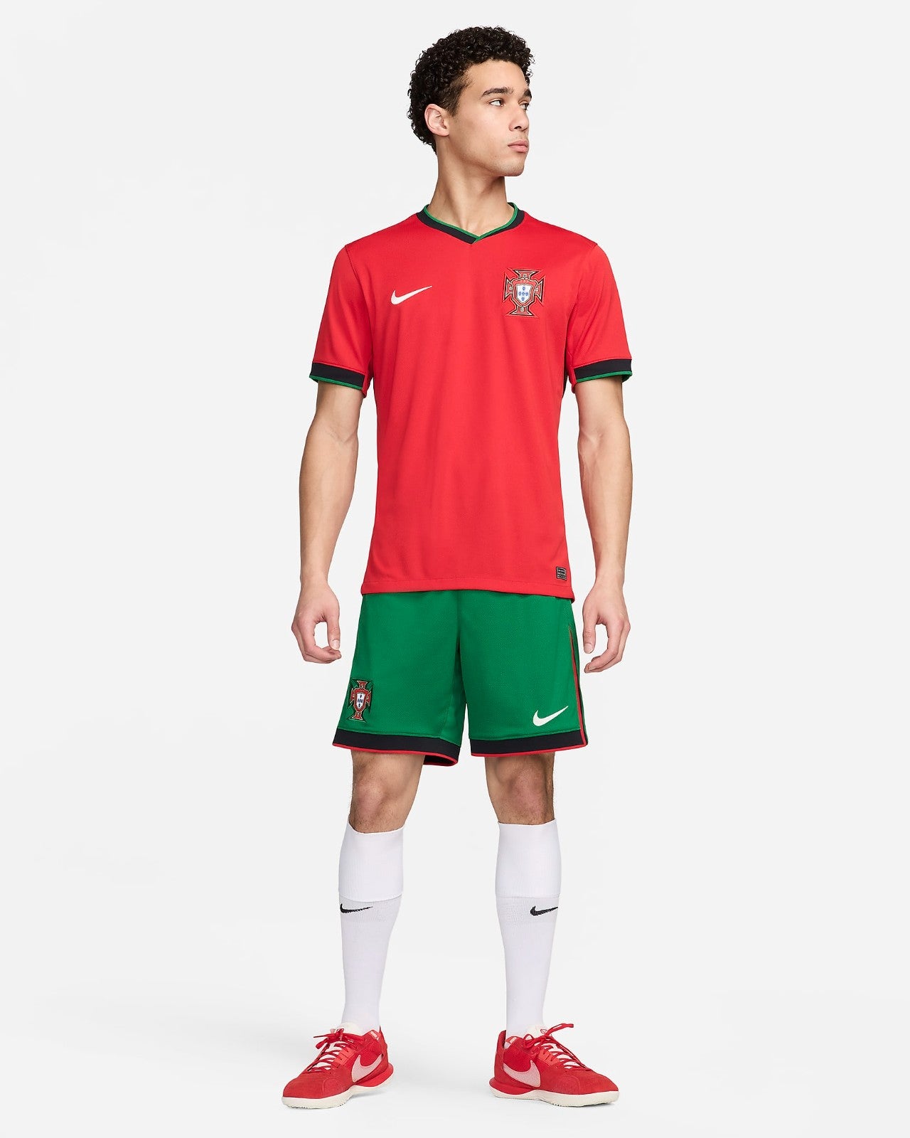 0GC5esDC5cQ90DK | UAE SPORT STORE Male model in Portugal national team kit—red jersey with crest and green shorts, white socks, and red shoes.