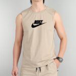 Tan sleeveless ribbed Nike tank top on a person, with the black Nike swoosh on the chest Vector is centered here.