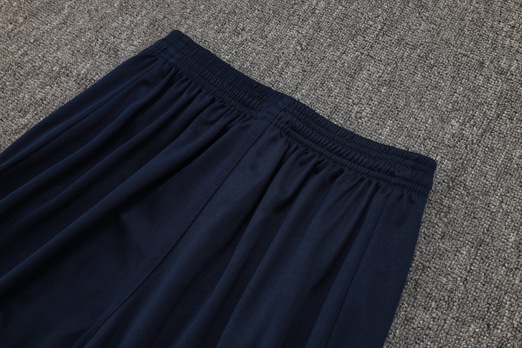 0b26cbaa | UAE SPORT STORE Navy blue elastic-waist skirt laid flat on a gray carpet.