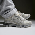 0bda7e35-09ac-452d-bd6b-73b4c776236f | UAE SPORT STORE Gray Asics running sneakers with a chunky sole, worn with light gray sweatpants/leggings.