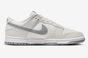 White Nike sneaker with light gray swoosh, low-cut design, and white midsole viewed from the side.