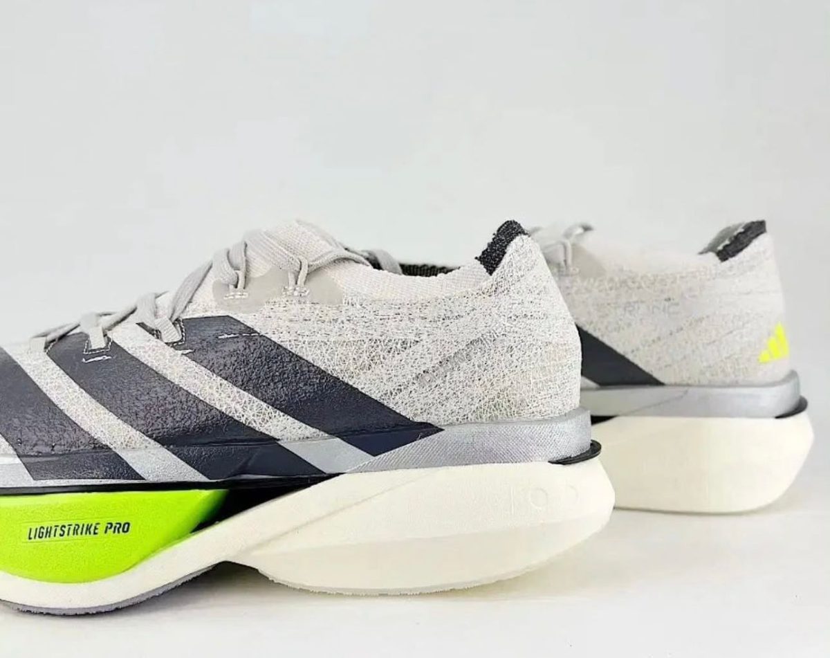 Pair of gray running shoes with neon lime green heel detail and a textured upper, shown from the side.