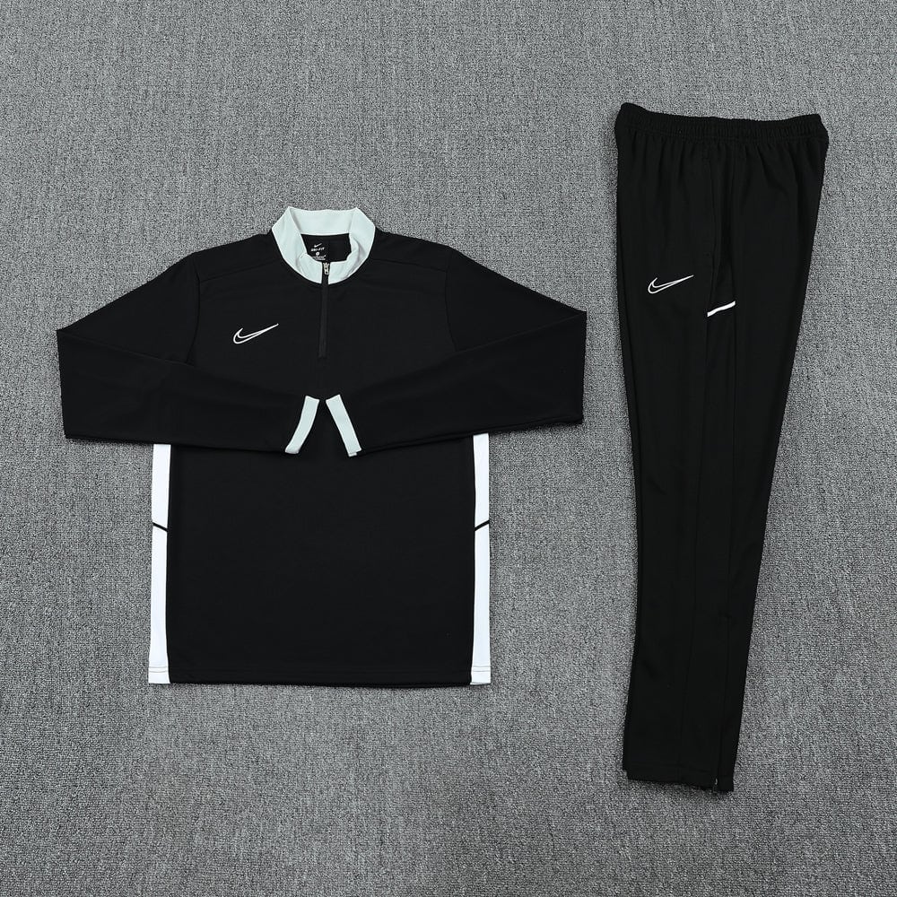 0cdf32de | UAE SPORT STORE Black Nike tracksuit laid flat: long-sleeve top with light gray collar and white side panels, plus matching black pants with white swoosh.