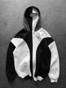 0df12b1c-f50a-4d7f-b18c-d210e4af0ea4 | UAE SPORT STORE Black and white color-block hoodie with a full front zipper and two front pockets