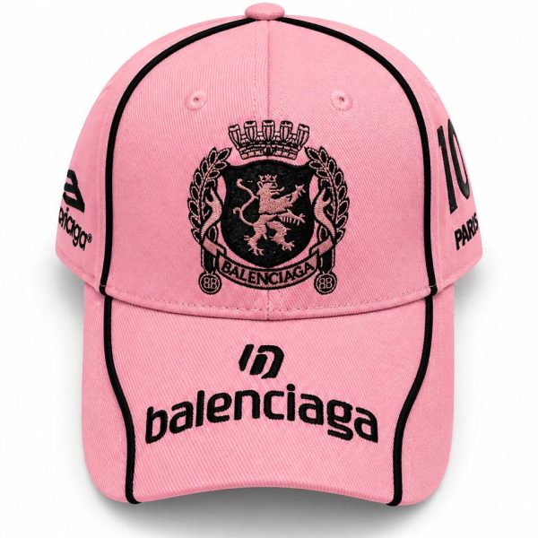 Pink Balenciaga baseball cap with black embroidered crest on the front and 'balenciaga' logo on the curved brim, white background.