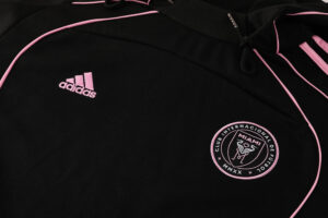 0e9e938d | UAE SPORT STORE Black Adidas hoodie with pink piping and a circular Miami football club crest on the chest. The pink embroidered Adidas logo is on the left.