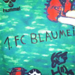 Close-up of a teal sports jersey with bold black text reading '1.FC BLAUMEI' and the Hummel logo.