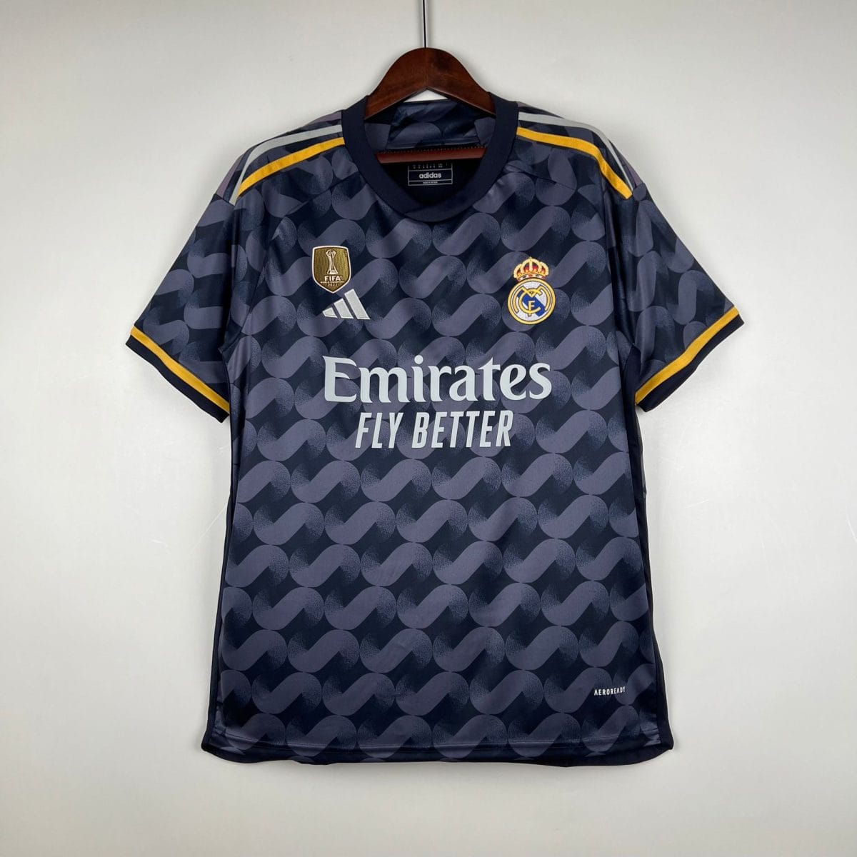 Dark blue Real Madrid football jersey on a hanger, featuring Adidas logo, crest, FIFA World Champions 2022 badge, and Emirates sponsor.