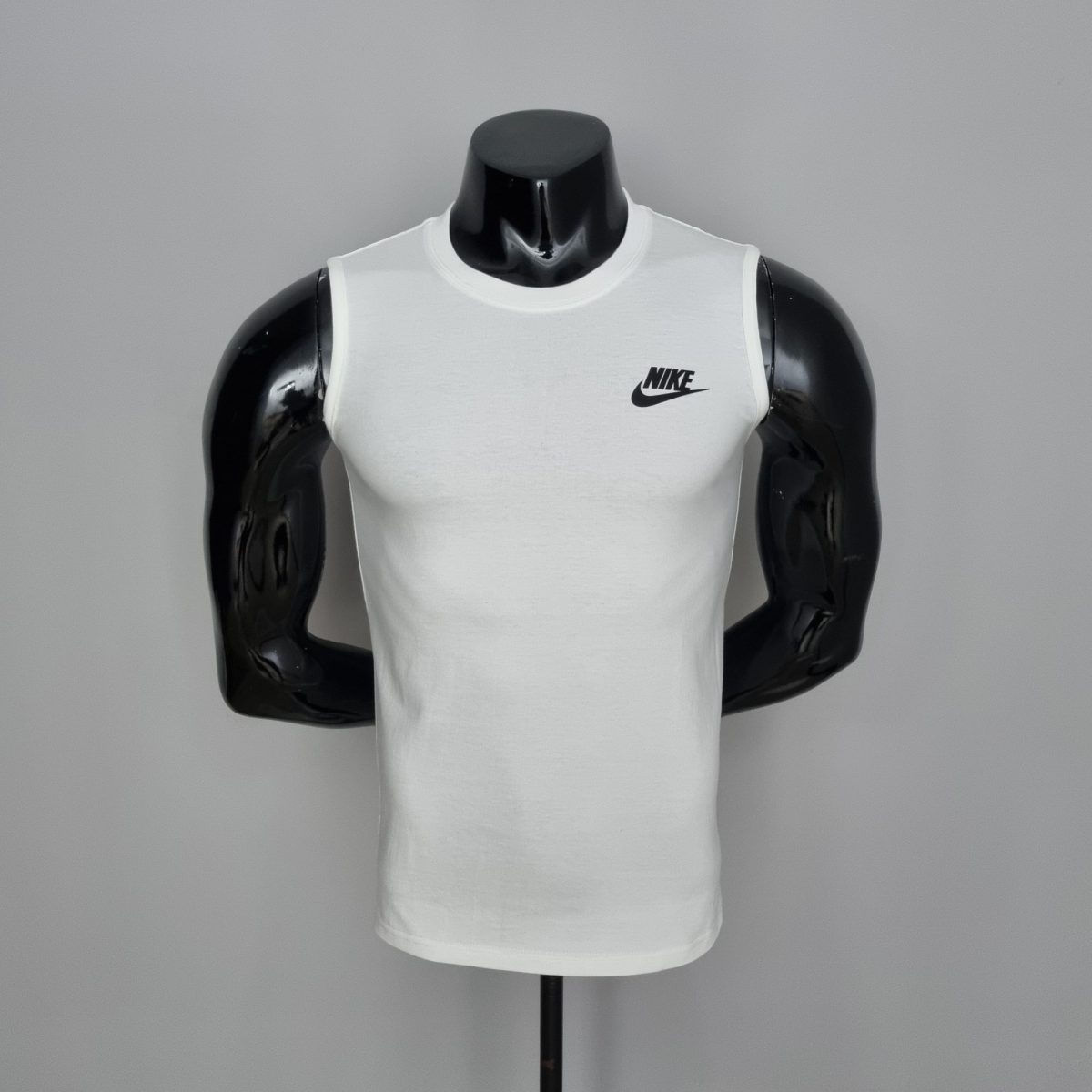 White Nike sleeveless tank top displayed on a black mannequin torso against a gray background.
