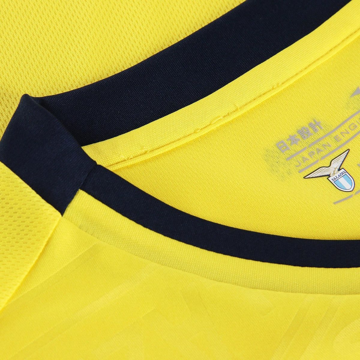 Close-up of a bright yellow sports jersey collar with a dark navy stripe and small emblem.
