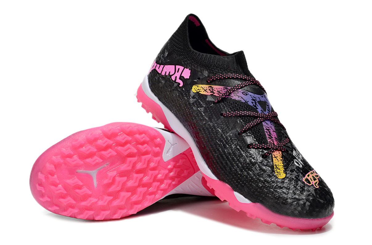 10014ae0 | UAE SPORT STORE Pair of black athletic shoes with bright pink outsoles and multicolor laces, angled to show tread patterns on the bottom edge of the shoe.