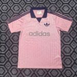 Pink Adidas polo shirt with navy collar and three navy stripes on sleeves, large gray Adidas logo across the chest.