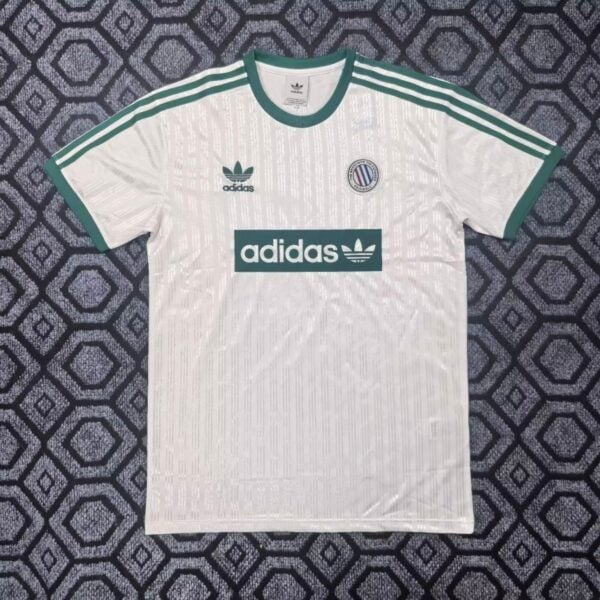 White Adidas soccer jersey with green trim, three green stripes on the shoulders, Adidas logo on the chest, and a circular club crest on the left.