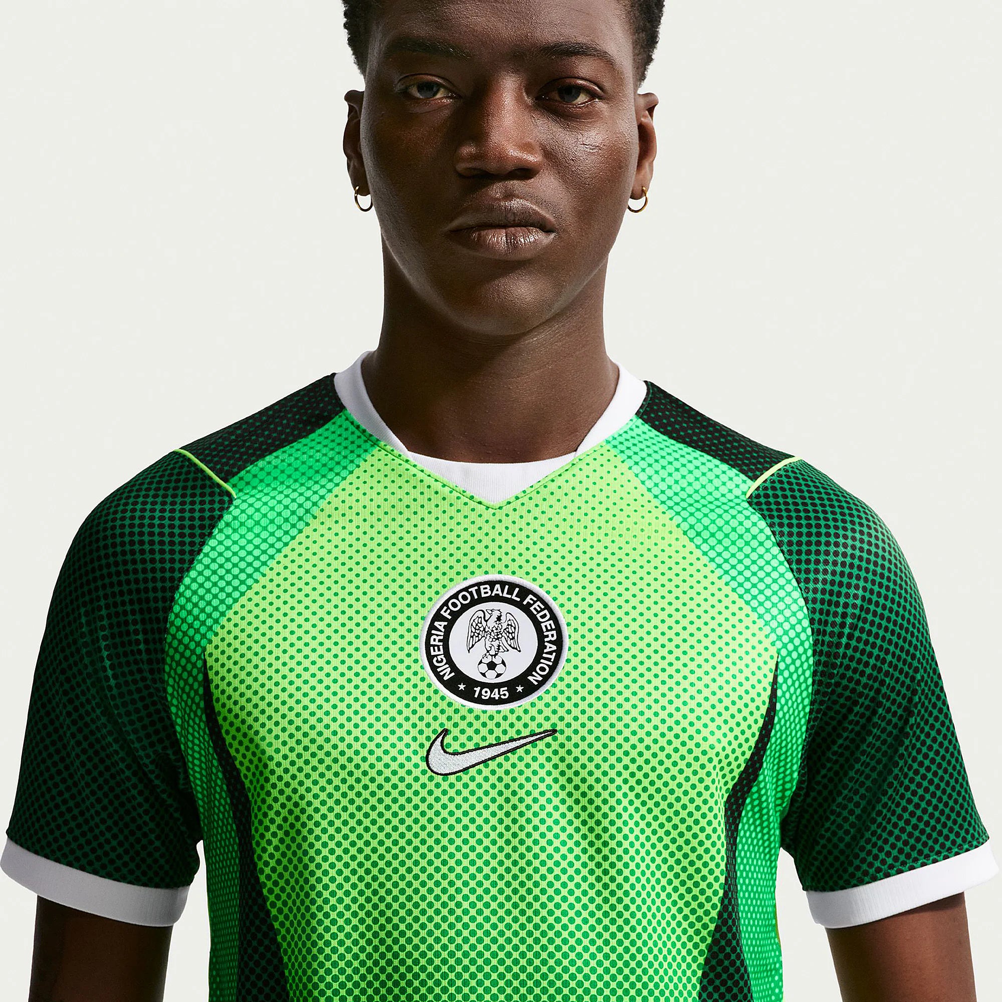 1053586_Gallery_2 Close-up of a person wearing a green dotted soccer jersey with a circular Nigeria Football Federation badge on the chest