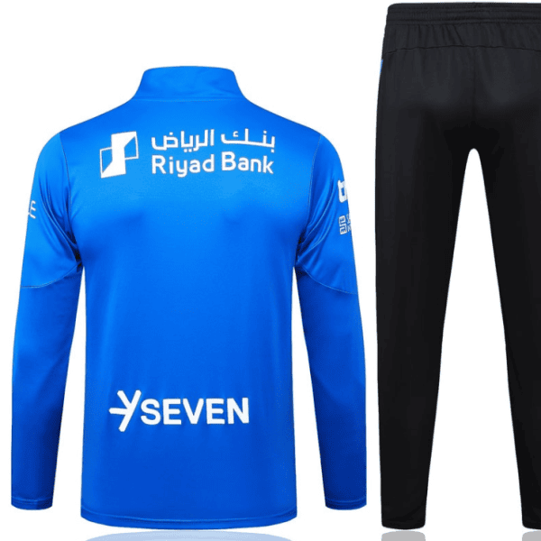 Back view of a blue long-sleeve athletic jersey with Riyad Bank and Seven logos paired with black track pants.