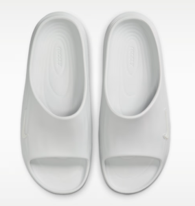 Pair of white open-toe slide slippers viewed from above, top-down perspective.