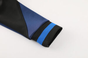 117eab06 | UAE SPORT STORE Close-up of a blue sleeve with a black cuff featuring two bright blue stripes on the cuff edge.