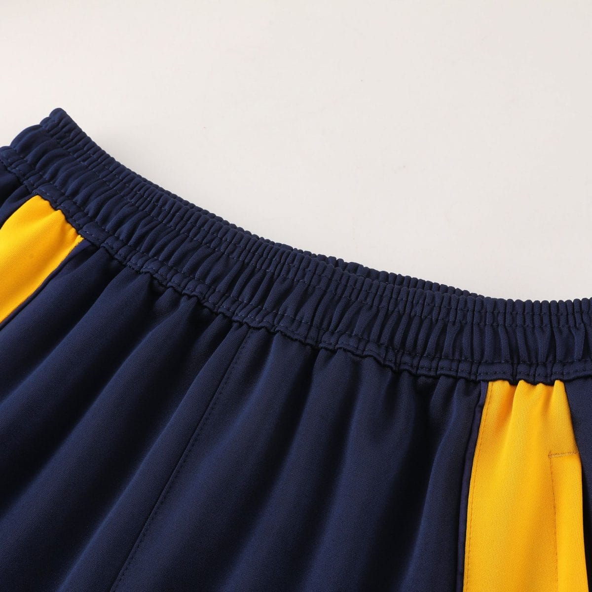 Close-up of dark navy fabric with an elastic waistband and a yellow accent strip along the edge.