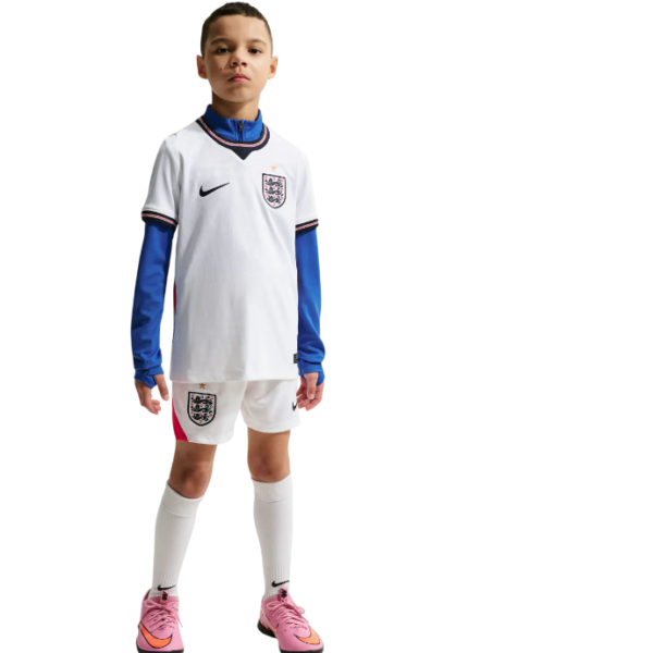 Young boy wearing England football kit: white jersey with crest, blue undershirt sleeves, white shorts, pink soccer cleats.