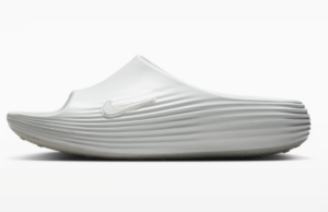 White slip-on Nike running shoe with a sculpted, ribbed midsole, side view