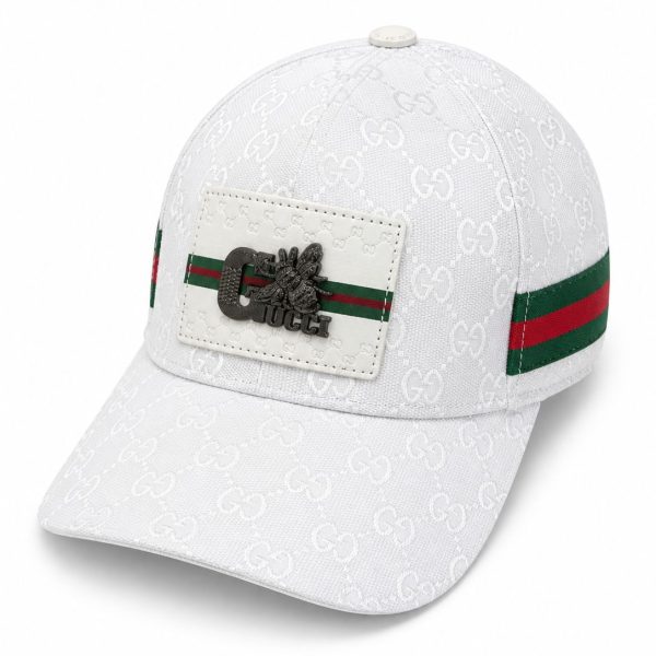 White Gucci baseball cap with allover embossed GG pattern, red-green stripe, and a white patch featuring a metallic bee and 'Gucci' text