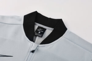 Close-up of a light blue Nike Dri-FIT jacket collar with a black ribbed neckline and zipper pull visible inside.