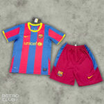 FC Barcelona home football kit: blue and red striped jersey with UNICEF sponsor and club crest, paired with maroon shorts with blue sides and yellow Nike swoosh on a concrete background.