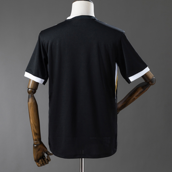 Back view of a black athletic jersey on a mannequin, white cuff trim on the sleeves, plain design visible from behind.