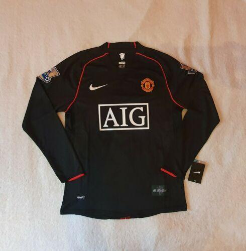 12_e6ad788b-eb7b-4f82-8e4e-56c5bccf9f72 | UAE SPORT STORE Black Manchester United long-sleeve jersey with red piping, AIG sponsor logo, and club crest on the left chest; Nike swoosh on the right sleeve edge, laid flat on a light surface.