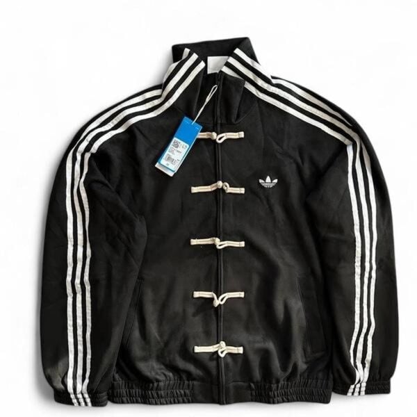 Black Adidas track jacket with white stripes on the sleeves and toggle closures down the front.