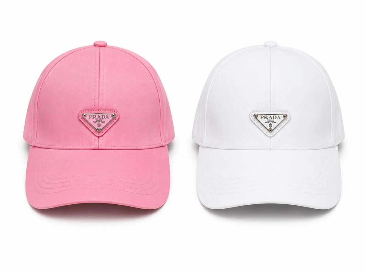 Two Prada baseball caps side by side: pink on the left and white on the right, each with a triangular logo patch on the front.