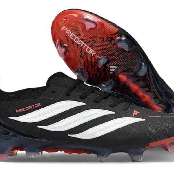 Black Adidas Predator soccer cleat with white side stripes and red sole details, shown with studded sole facing up for football use