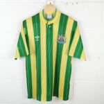 Newcastle United football jersey with green and yellow vertical stripes and club crest on the left chest, hanging on a hanger
