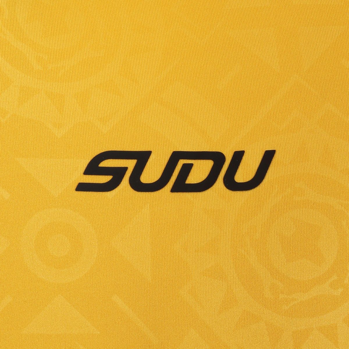 Close-up of yellow fabric with bold black letters spelling 'SODU' printed on it